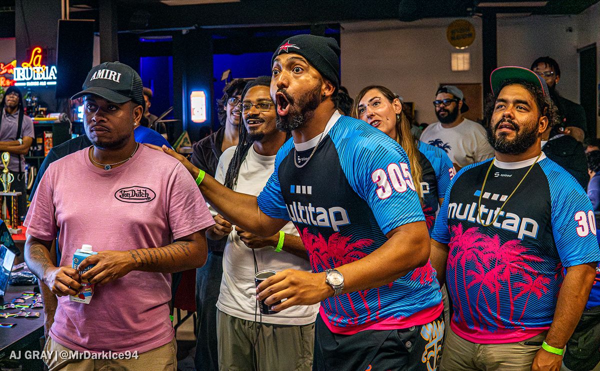 Team members in Multitap jerseys reacting beside spectators