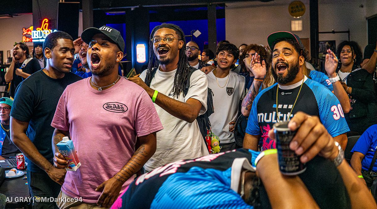 Team members and spectators reacting beside the match setups